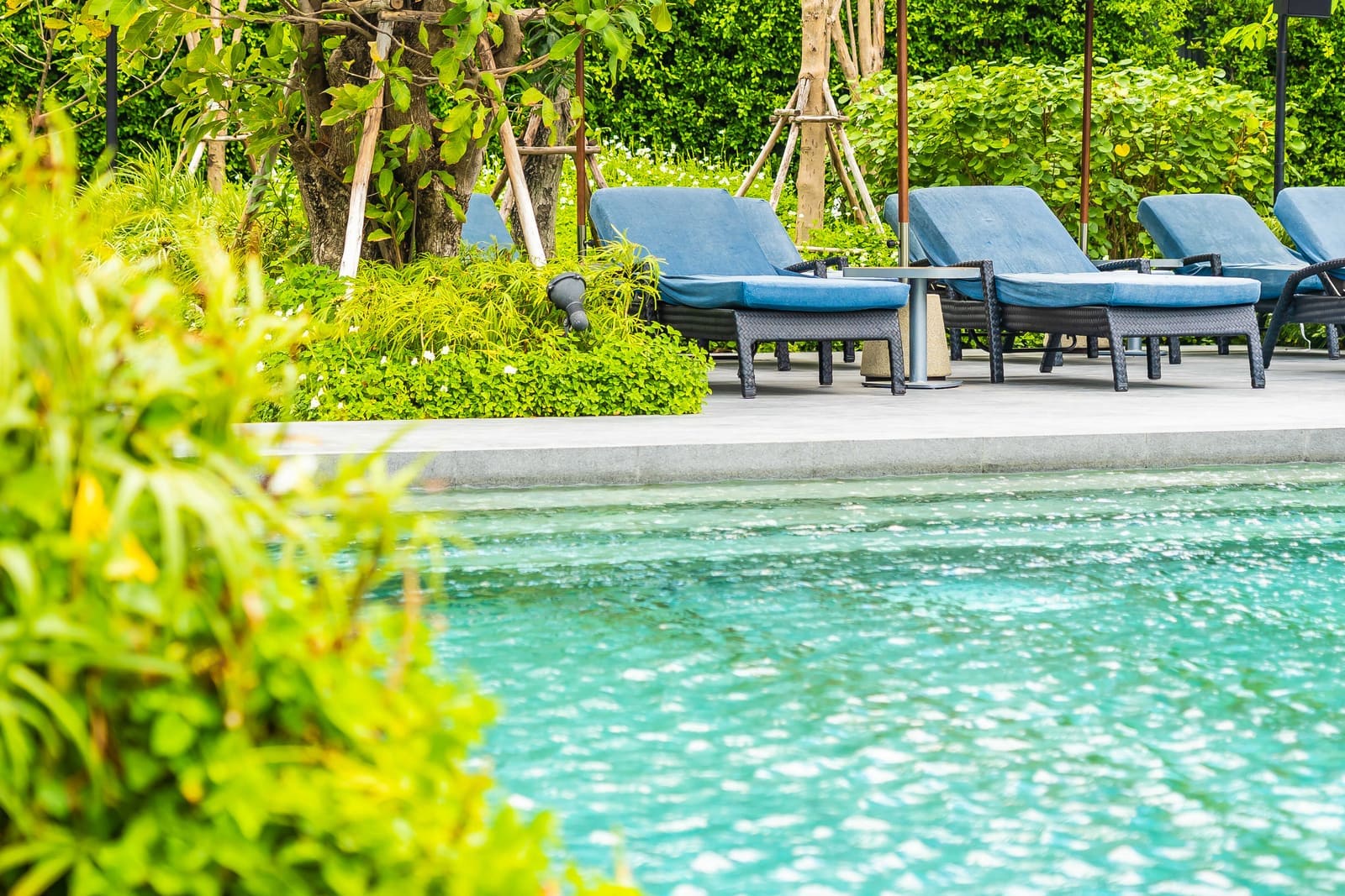 Outdoor hotel resort pool with deck chairs for a vacation setting