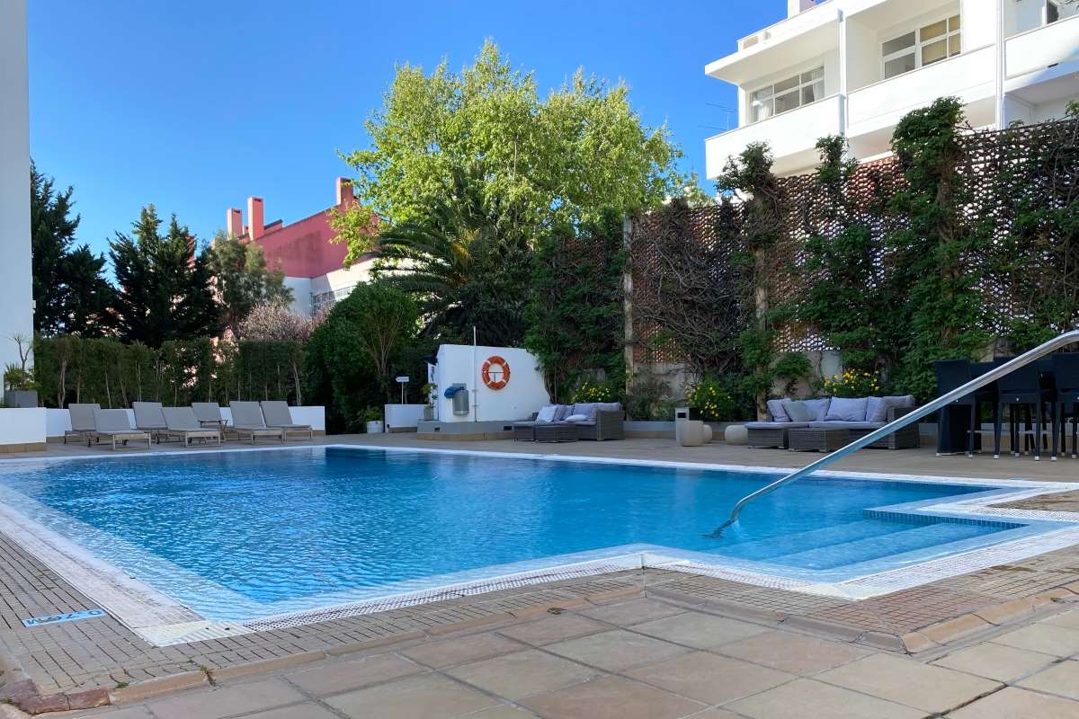 Pool service pricing in practice — sunny residential pool with the clear water that signals routine recurring service
